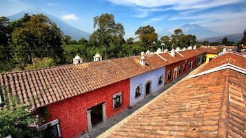 A red building with a tiled roof and a white building with a tiled roof.