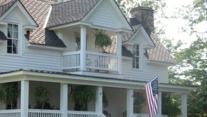 A two-story house with a porch, a chimney, and an American flag. - Seventy-four Ranch (Jasper)