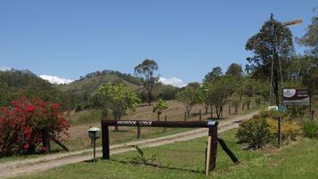 A sign for Amamoor Lodge with a dirt path leading to it.