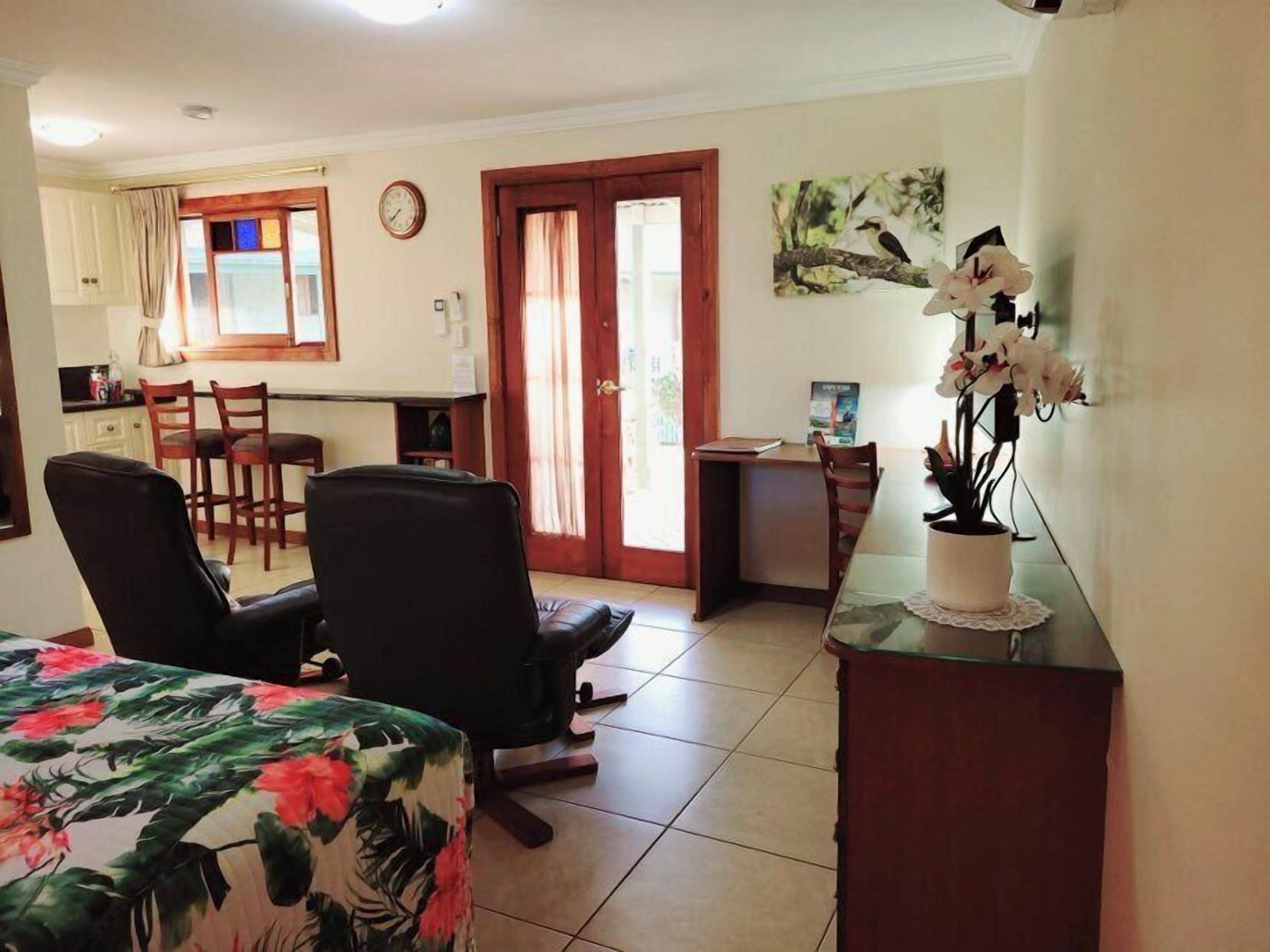 Une pièce de taille modeste comprenant un lit, un bureau, une chaise et une petite kitchenette.