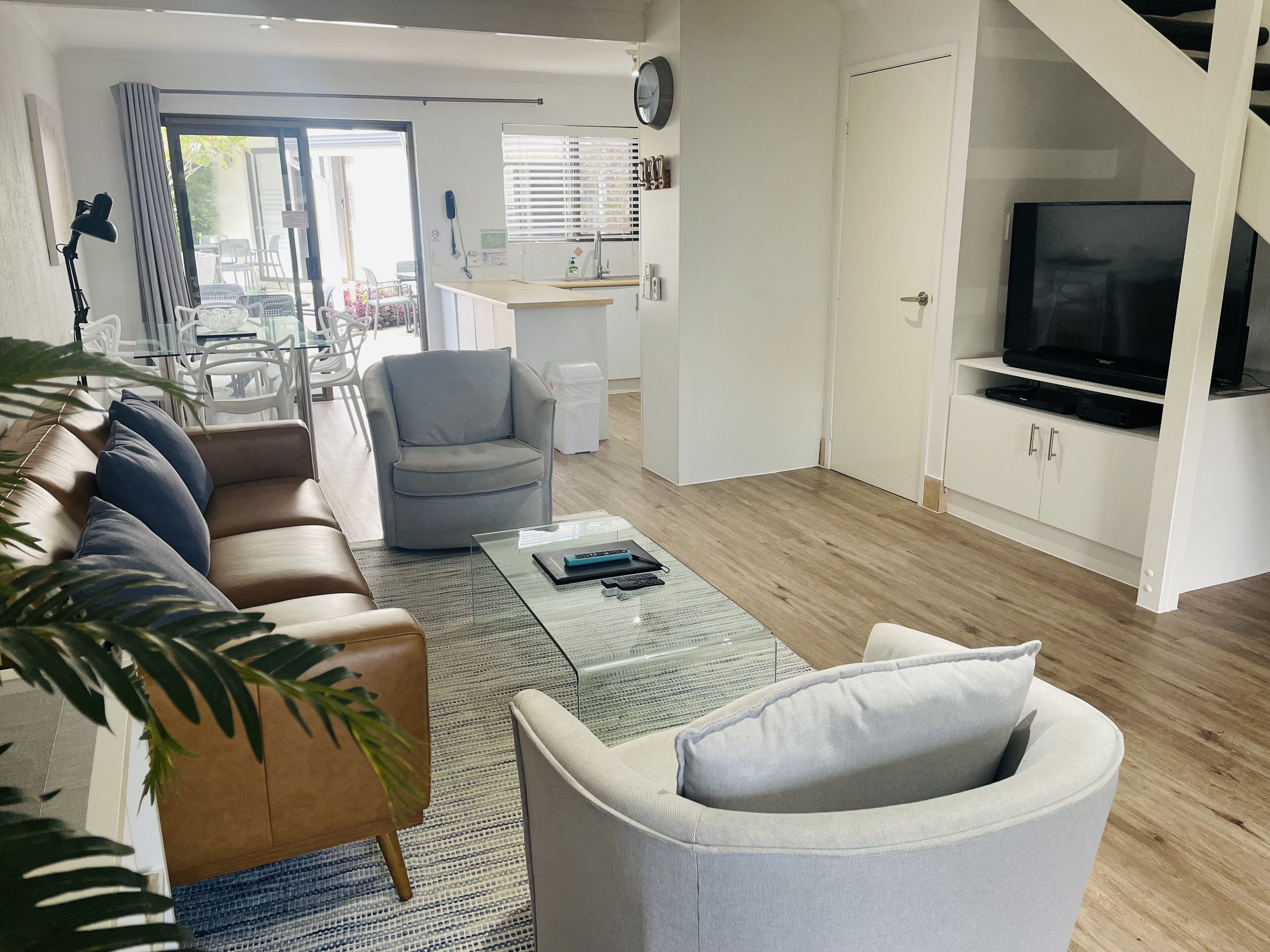 A modern living room with a sofa, armchairs, a coffee table, and a TV.