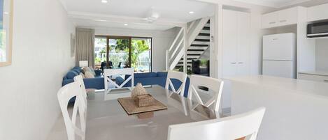 A modern kitchen with white cabinets, a built-in microwave, and a refrigerator.