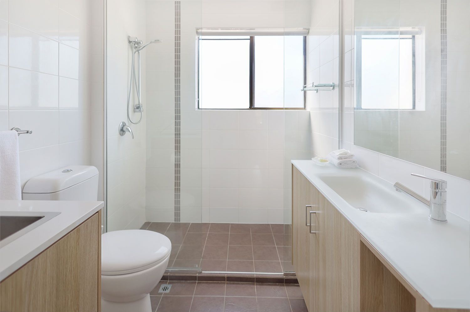 A modern bathroom with a shower, toilet, and sink.