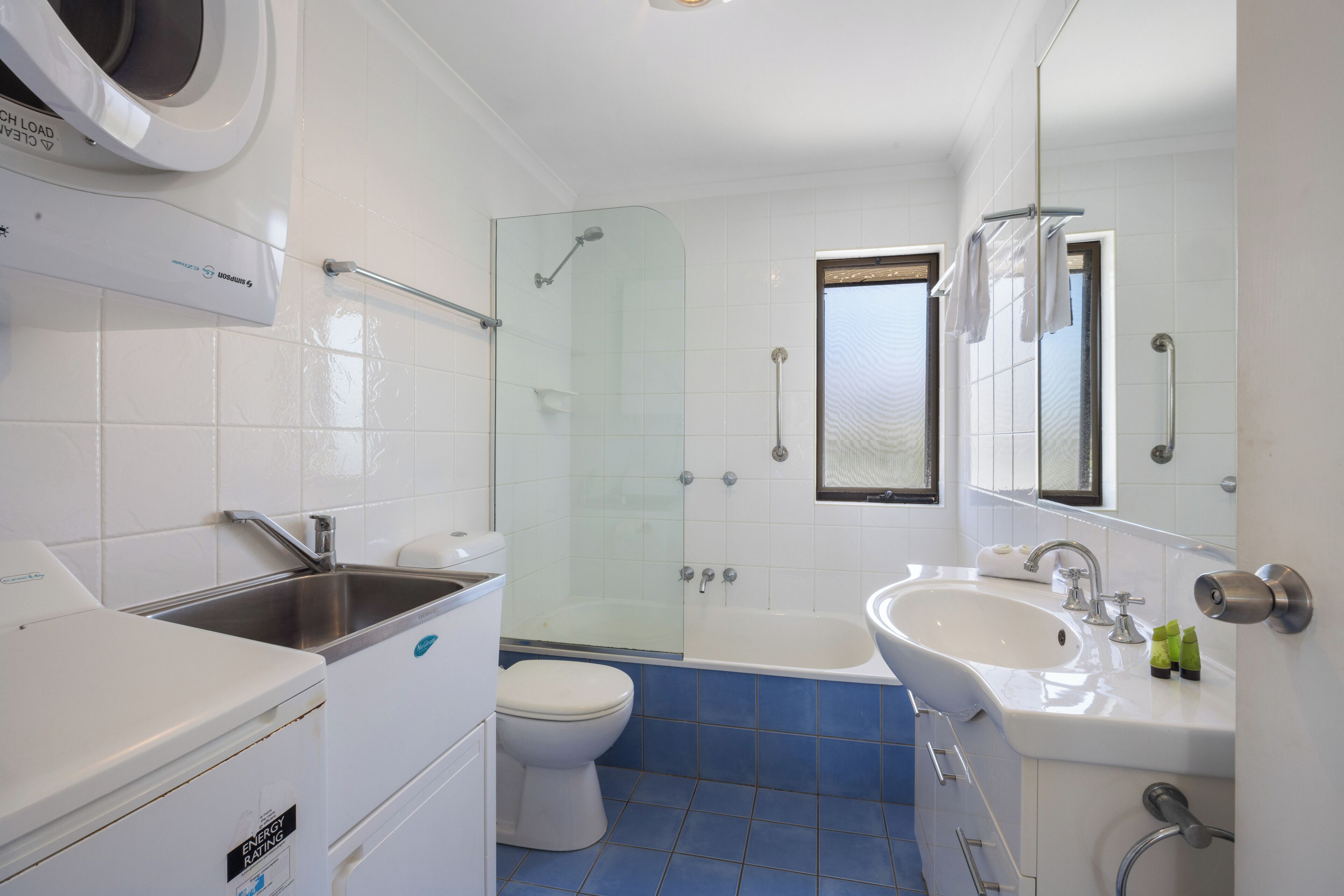 A modern bathroom with a shower, toilet, sink, and a glass-enclosed shower area.