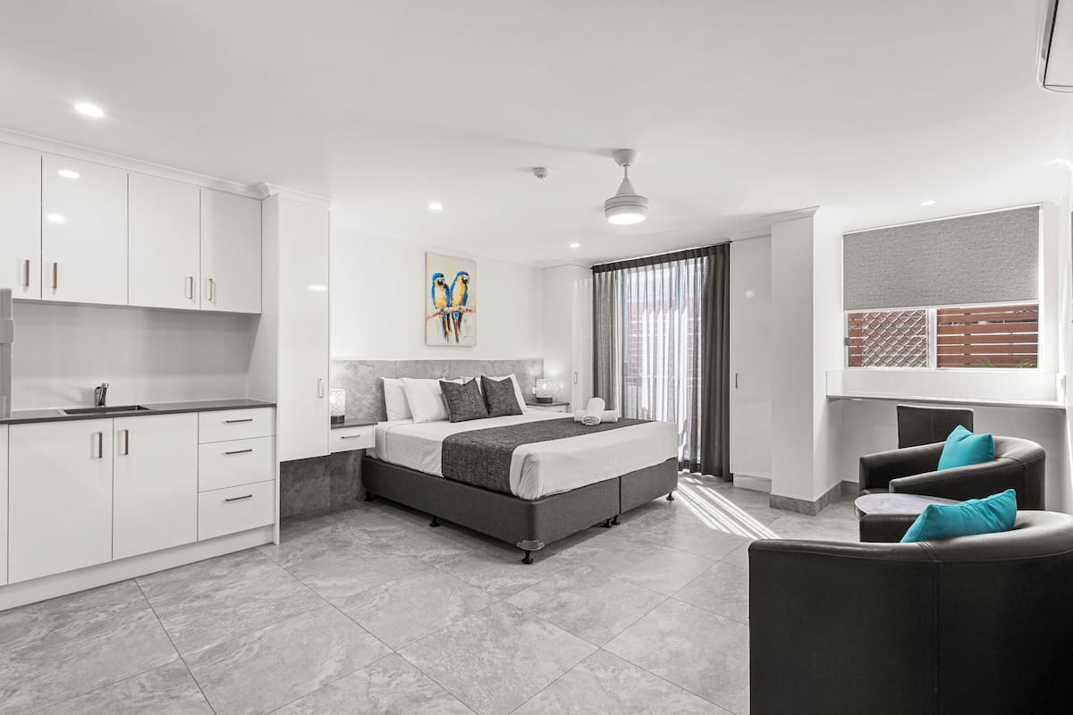 A modern bedroom with a large bed, a desk, and a chair.