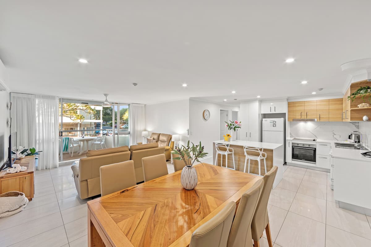 A modern apartment with a dining area, kitchen, and living room.