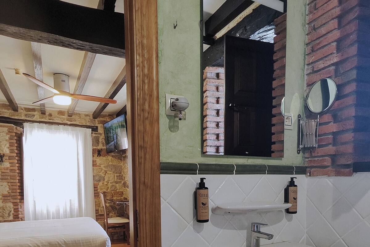Une salle de bain avec un lavabo blanc, un miroir et une serviette accrochée au mur.