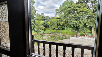 Uitzicht vanaf een balkon met stenen vloer en een metalen leuning.
