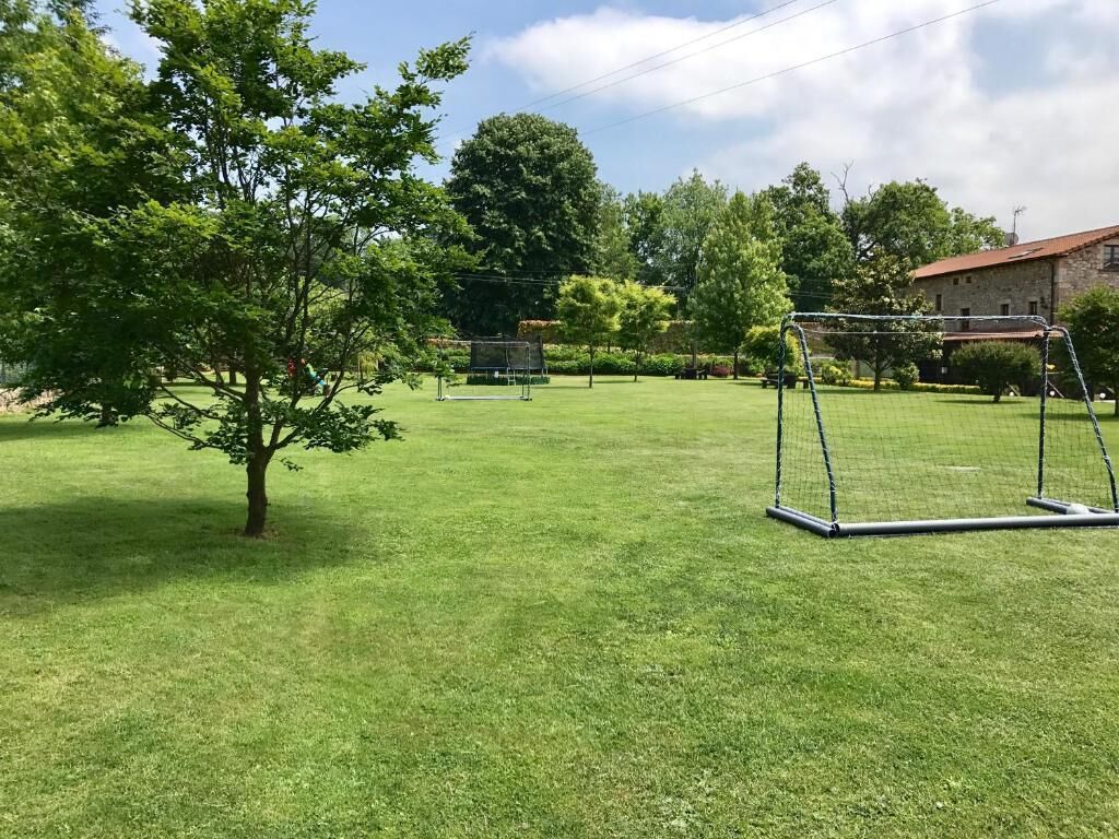 Un espace extérieur verdoyant avec une balançoire et un but de football.