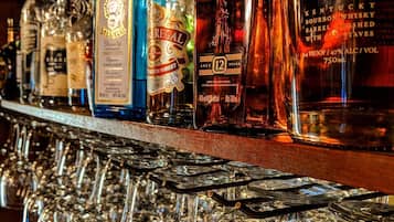 A bar with various bottles of liquor and a large number of glasses.