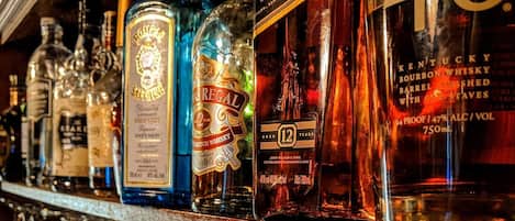 Un bar où l’on trouve une variété de bouteilles d’alcool et un grand nombre de verres.