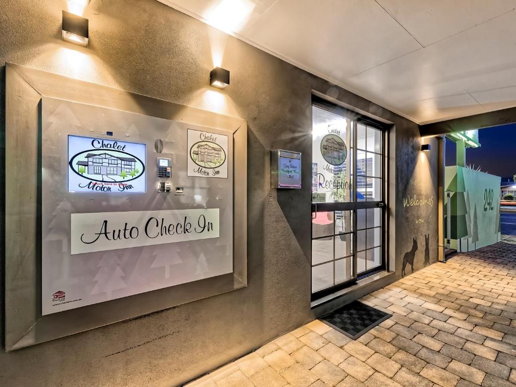 Ein Hotel Eingang mit einer Rezeption, einem Schild für 'Auto Check In' und einem 'Willkommen'-Schild.