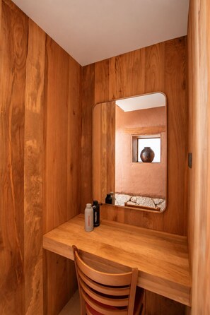 Une pièce en bois avec un bureau, une chaise et un miroir.