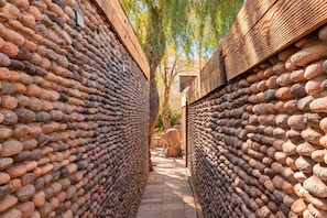 Un étroit sentier bordé de murs construits avec de grandes pierres arrondies.