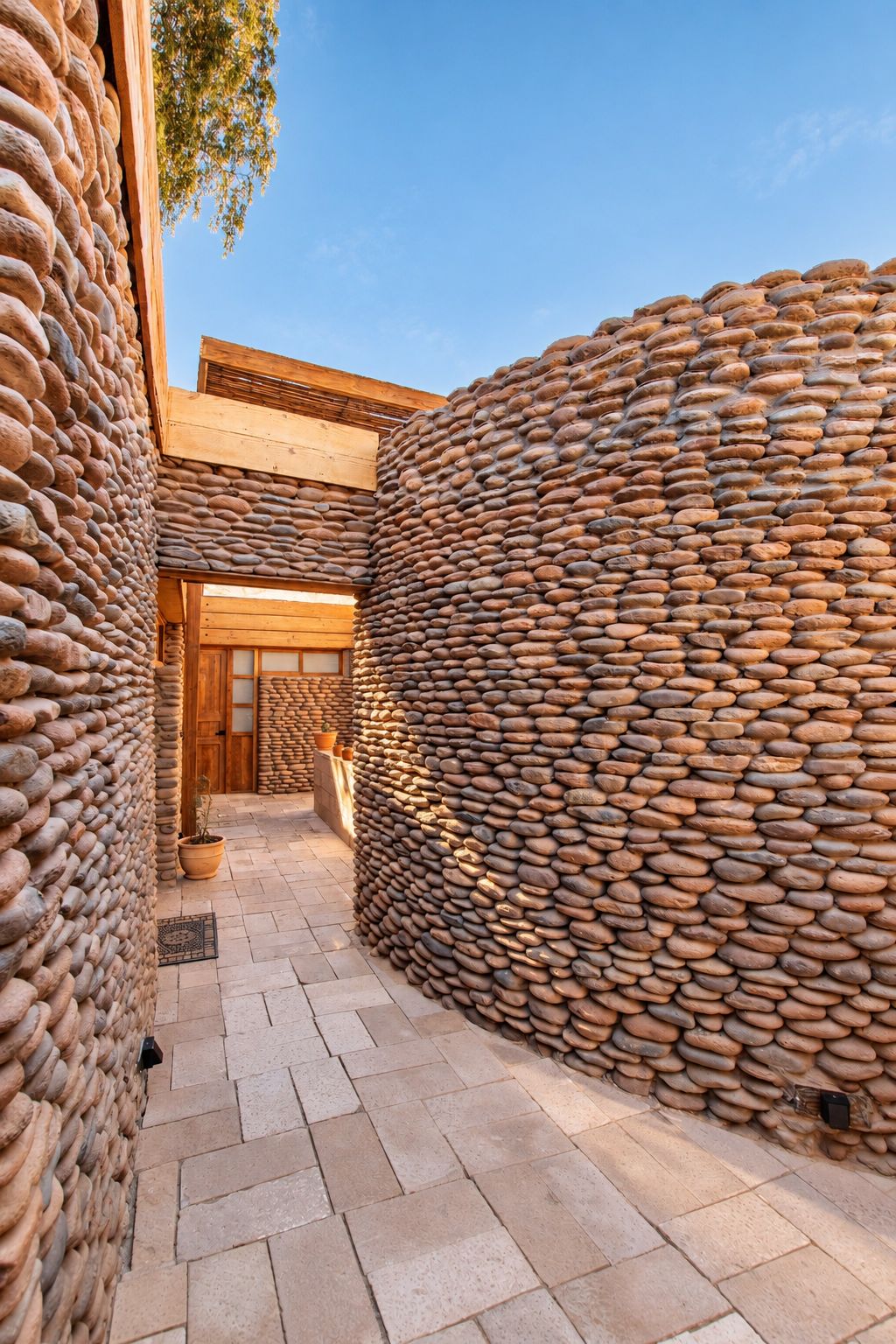 Un patio con muros de piedra, una puerta de madera y suelo de baldosas.