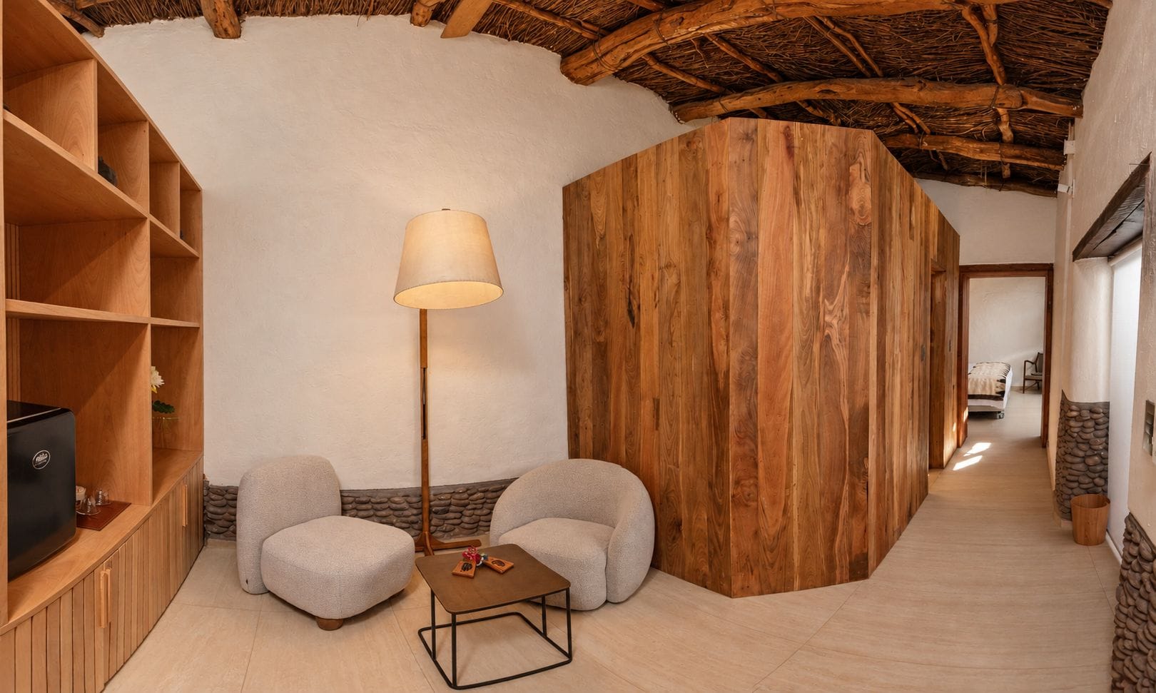 Ein gemütliches Zimmer mit Holzboden, einer Couch, einem kleinen Tisch und einer Lampe.