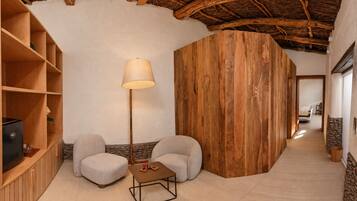 Ein gemütliches Zimmer mit Holzboden, einer Couch, einem kleinen Tisch und einer Lampe.