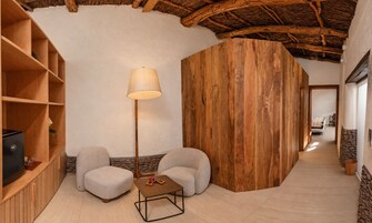 Una habitación acogedora con suelo de madera, un sofá, una mesita y una lámpara.