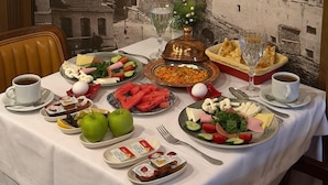 A table set with various breakfast items, a painting of a lighthouse, and a chair.