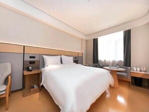 Una habitación de hotel moderna con una cama grande, mesitas de noche, un escritorio y una silla.