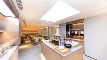 A modern kitchen with a central island, built-in appliances, and a bright overhead light.