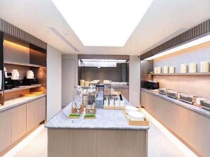Una cocina moderna con una isla central, electrodomésticos integrados y un tragaluz.