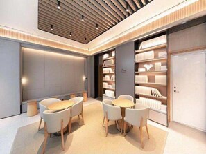 A modern interior with a central seating area, bookshelves, and a closed door. - Ji Hotel (Xi'an)
