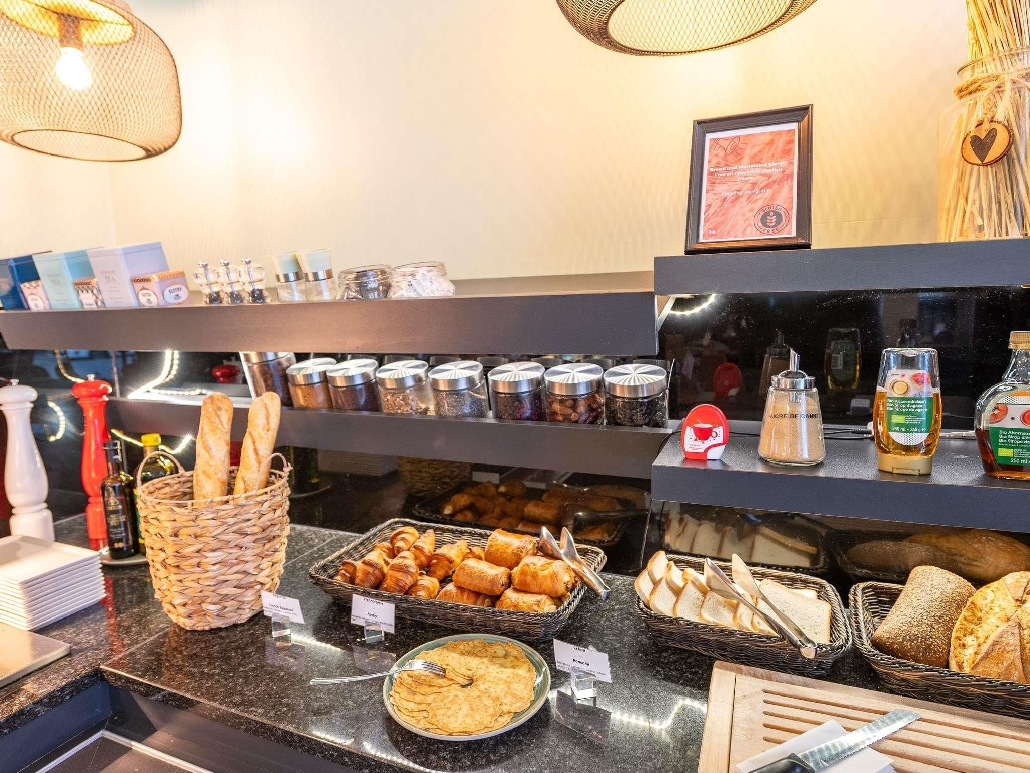 Un bufé de desayuno con panes, pasteles y salsas.