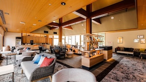 A spacious lobby with high ceilings, a central seating area with sofas and chairs, a bar area with shelves, and a kitchen visible through the glass walls. - Hyoe Koyokaku (Kobe)