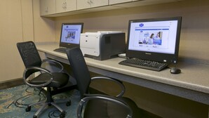 A workspace with two computers, a printer, and two office chairs. - Hampton Inn & Suites Wiggins (Wiggins)