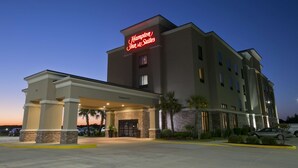 A Hampton Inn & Suites hotel with a well-lit entrance, a covered parking area, and a clear sky at dusk. - Hampton Inn & Suites Wiggins (Wiggins)