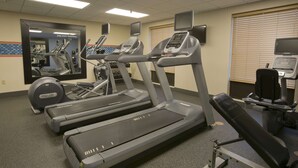 A gym with treadmills, an elliptical, and a bench. - Hampton Inn & Suites Wiggins (Wiggins)