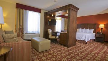 Une chambre d’hôtel équipée d’un lit, d’un bureau, d’une chaise, d’un climatiseur et d’un téléviseur.