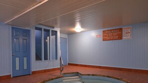 Zona de piscina con un cartel que indica las normas de la piscina y del spa.