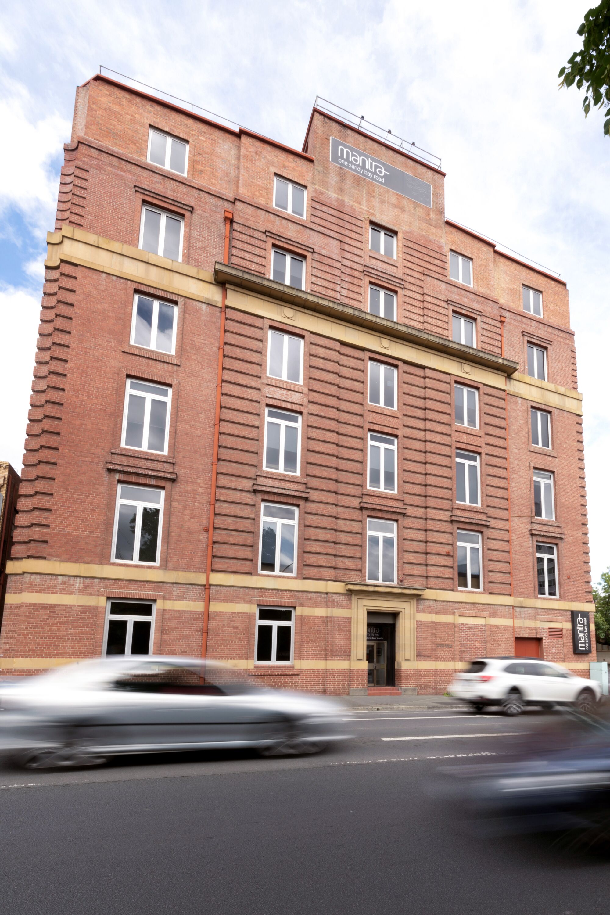 A multi-story brick building with a sign that reads "mantra."