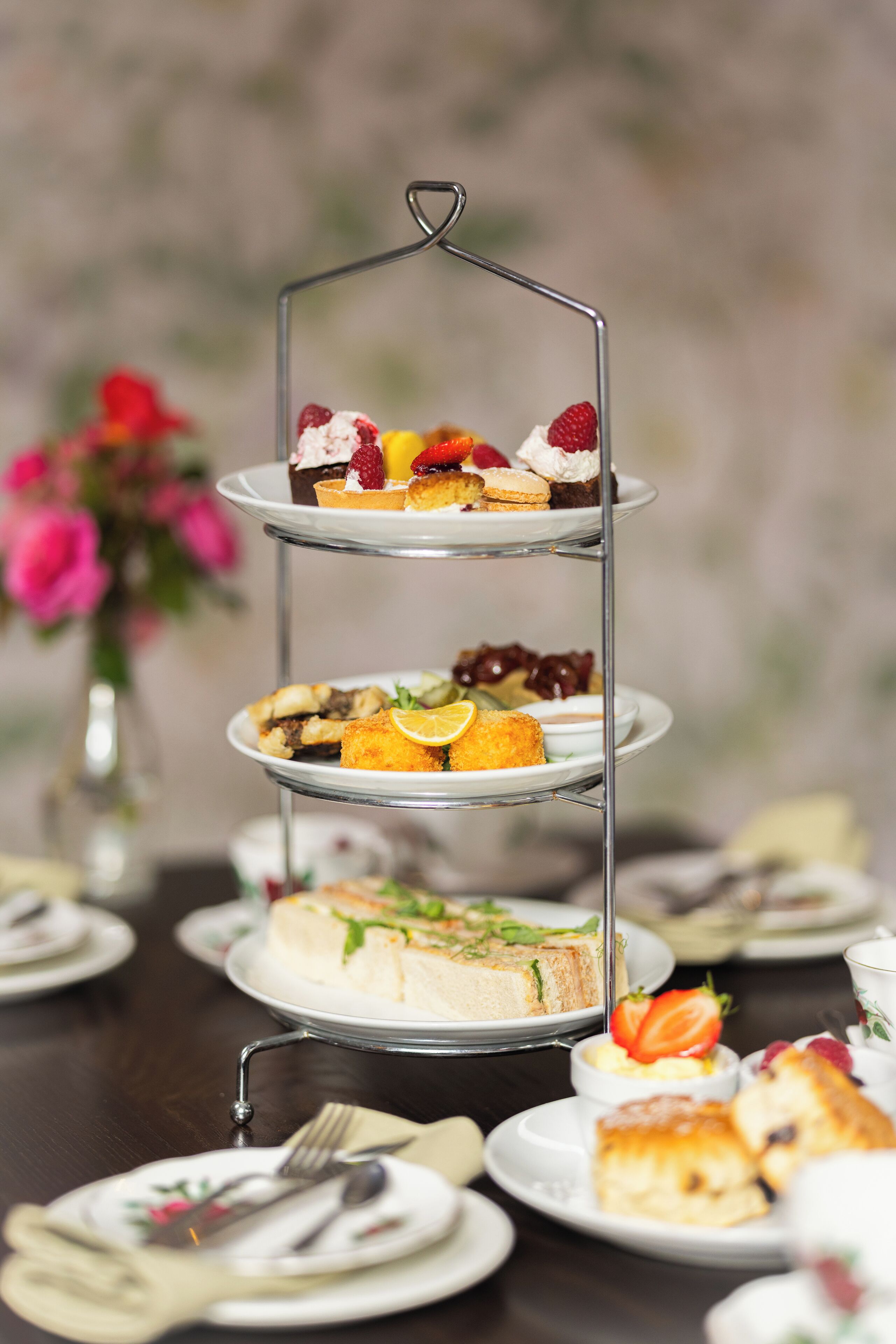 A three-tiered dessert stand with various pastries and desserts.