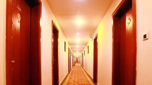 Un pasillo de hotel con puertas de madera y piso alfombrado.