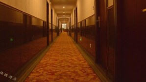 A long, narrow hotel corridor with a carpeted floor and wooden doors on both sides. - GreenTree Inn Changzhou Xinbei District Taihu Road Wanda Square Express Hotel (Changzhou)