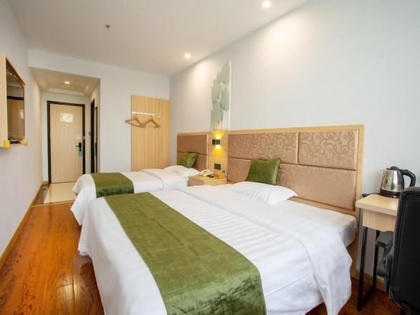 Une chambre d’hôtel avec deux lits, un bureau et une chaise.