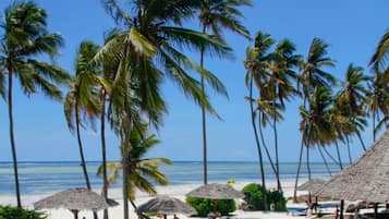 On the beach, white sand, sun-loungers, beach umbrellas