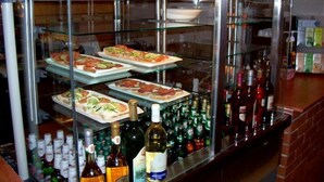 A buffet area with various food items and a selection of alcoholic beverages. - Timon (Budapest)