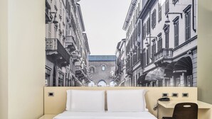Una habitación de hotel con una cama grande, un escritorio y una silla.