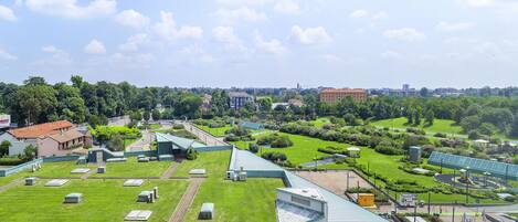 A large, open green space with multiple buildings, including a prominent white structure with a sloped roof.