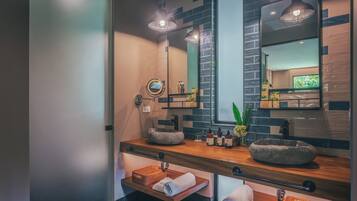 Un baño moderno con dos lavabos, un espejo grande y encimera de madera.