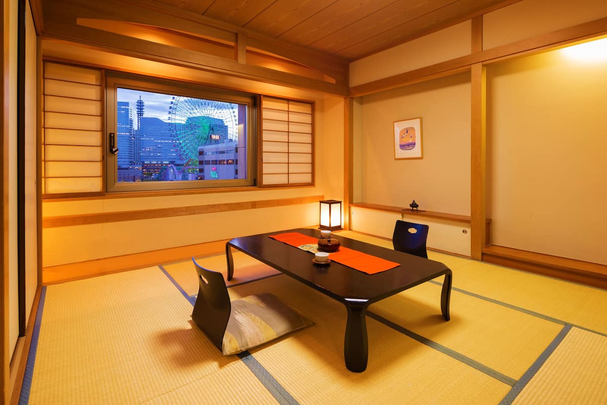 A traditional Japanese room with tatami flooring, a low table, and shoji screens.
