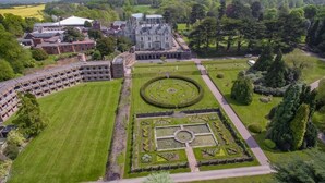 An aerial view of a large estate with a central circular garden, surrounding buildings, and extensive greenery. - Lilleshall National Sports Centre  (Newport)