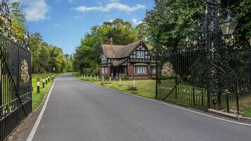Una casa de estilo Tudor con un camino pavimentado que conduce a un acceso con puerta.