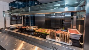 A commercial kitchen with stainless steel appliances, a glass partition, and various food items like potatoes and bread. - Lilleshall National Sports Centre  (Newport)