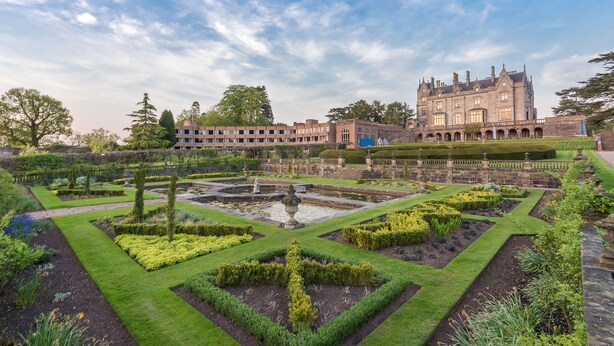 A historic building with a formal garden, including a central fountain and geometrically shaped hedges. - Lilleshall National Sports Centre  (Newport)