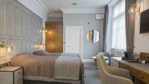 A hotel room with a bed, a desk, a chair, a mirror, and a wardrobe. - Lilleshall National Sports Centre  (Newport)